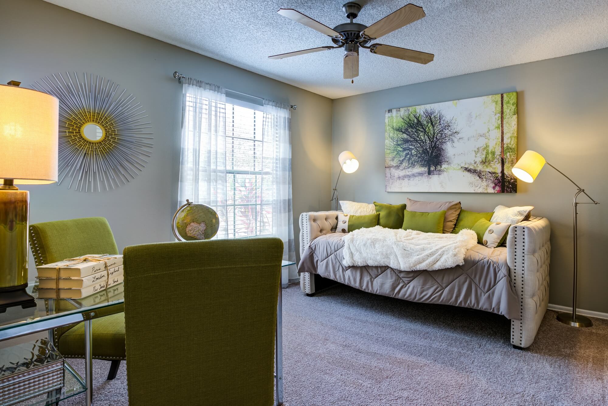 bedroom with large window, ceiling fan, and decor.