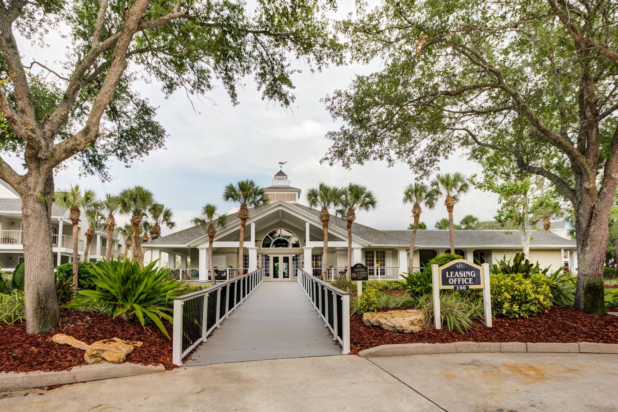 clubhouse and leasing office view with several palm trees.